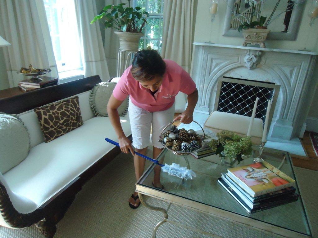 Original First Class Cleaning photo of a team member dusting a living room